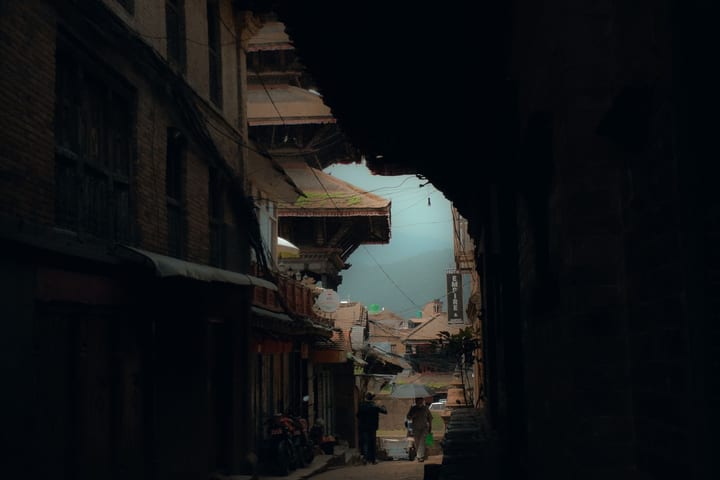 A very dark, underexposed night street scene with most of the detail lost in shadow
