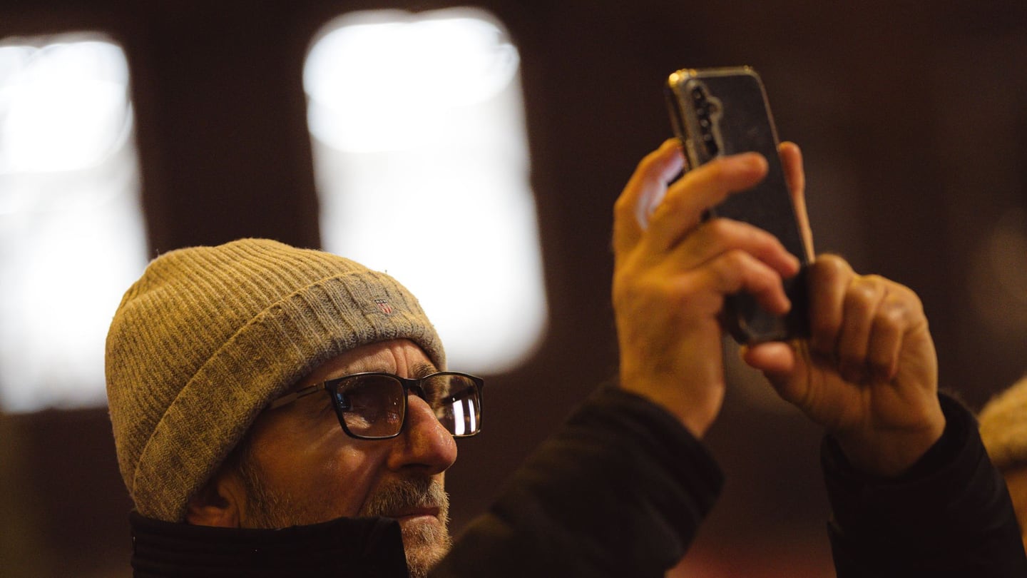 A person photographing a city at night with a smartphone